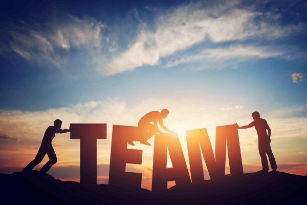 people connect letters to compose the team word. teamwork concept
